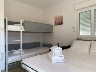 Chambre familiale lumineuse avec lit double et lits superposés au Mas du Camisard, idéale pour séjour avec enfants