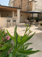 Cuisine d’été du Mas du Camisard avec terrasse ombragée, comptoir et tabourets, idéale pour les repas en extérieur dans le sud de la France