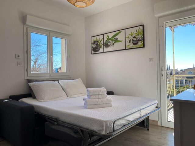 Chambre lumineuse avec lit double et vue sur le jardin au Mas du Camisard, hébergement confortable dans le Gard