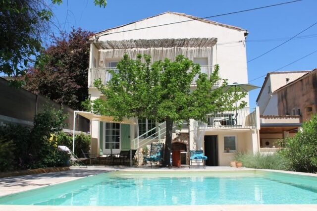 Vue d’ensemble du Mas du Camisard avec piscine turquoise, terrasse ombragée et végétation méditerranéenne, à Ribaute-les-Tavernes dans le Gard